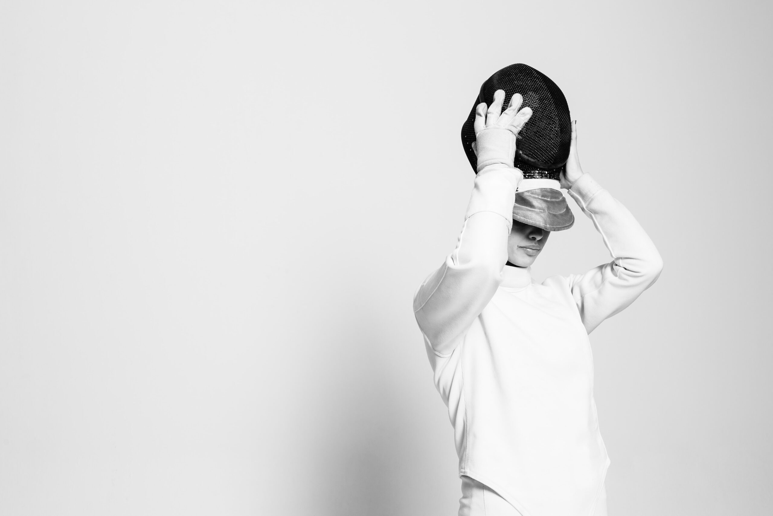 Fechterin die sich eine Fechtmaske anzieht